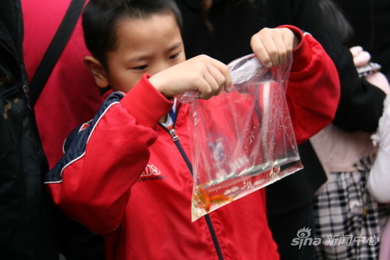 捐手機的孩子得到了即將親手放生的魚苗