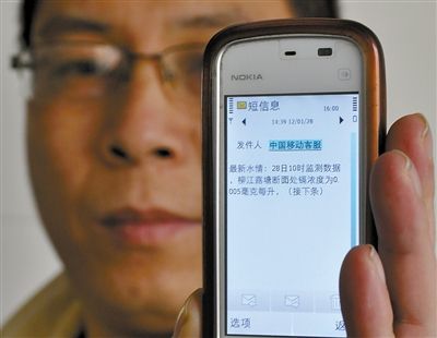28日，廣西柳州，一男子展示剛剛收到的水質監測情況短信。新華社記者 陸波岸 攝