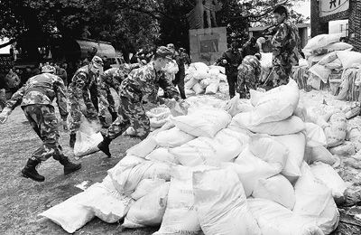 1月29日，在廣西柳州市柳城縣糯米灘水電站，武警戰士和消防官兵在搬運絮凝劑。新華社記者 陸波岸攝